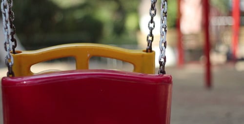 Empty Swing Gently Swings in an Urban Park