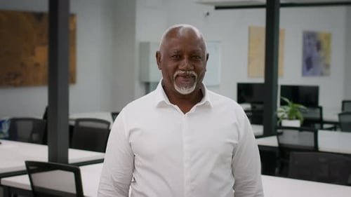 Mature Black Businessman In White Shirt Standing In Modern Business Center Indoors