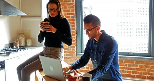Woman and Man Working on a Laptop at Home