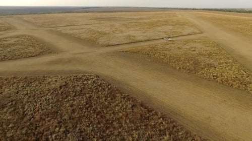 Vidéo d'un Drone au Ralentissement d'un petit avion roulant prêt à décoller sur une piste en jaune