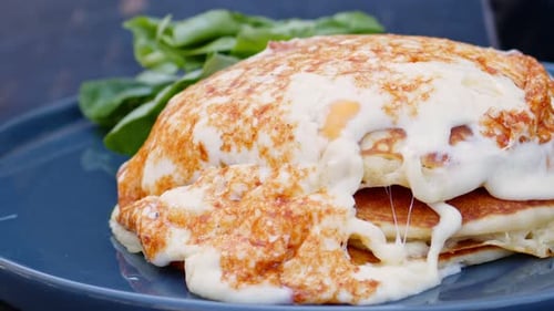 Golden Pancakes Topped With Melted Cheese on Plate