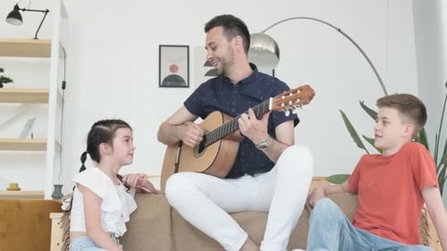 Father Plays Guitar for His Children at Home
