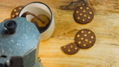 Pouring Coffee on Table with Cookies