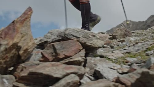 Hiker Using Poles On Rocky Mountain Trail
