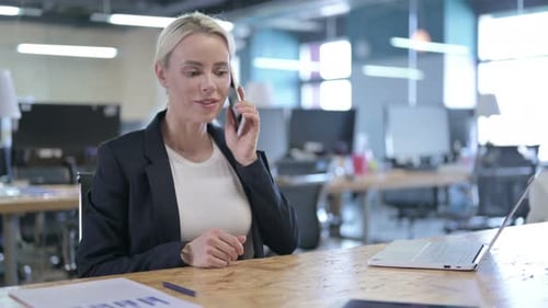Professional Woman Talking on Smartphone in Modern Office