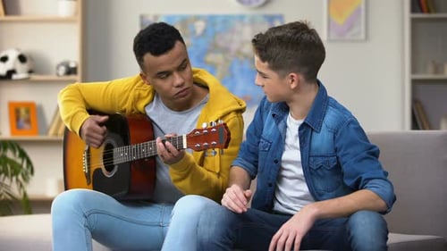 Teens Playing Guitar Together in Living Room