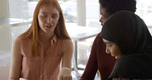 Young adult female friends hanging out in a cafe