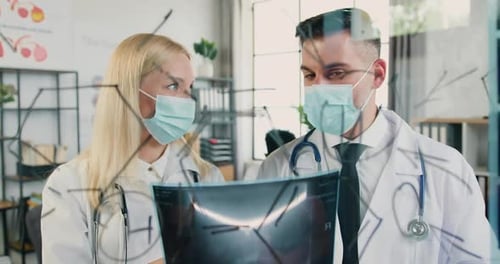 Doctors Analyzing X-Ray and Drawing Diagrams on Glass