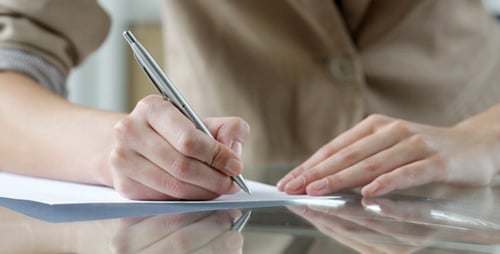 Writing on Paper with a Pen on Glass Desk