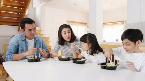 Happy Family Enjoying Noodle Meal Together at Home
