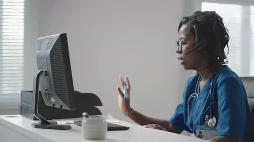 Young Woman Doctor Talking on Headset