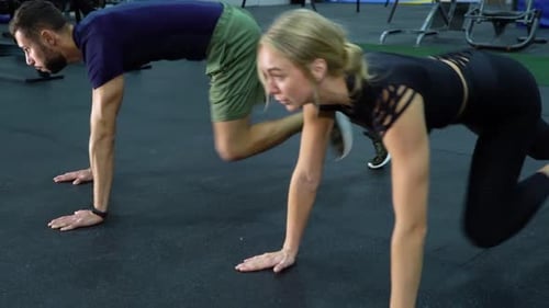 Fit Couple Doing Mountain Climber Exercise Gym
