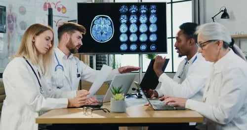 Medical Professionals Analyzing Brain Scans in Modern Office