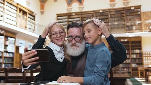 Senior Man Takes Selfie with Children in Library