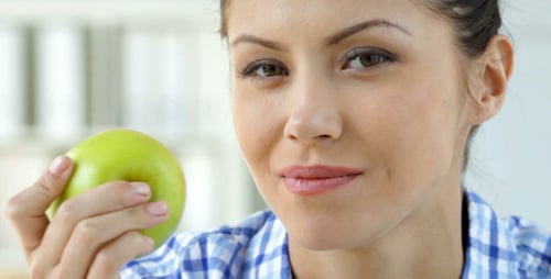 Woman Eats a Fresh Green Apple Close Up