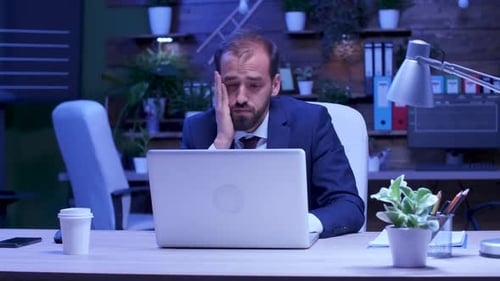 Overworked Businessman Sits in Front of the Computer