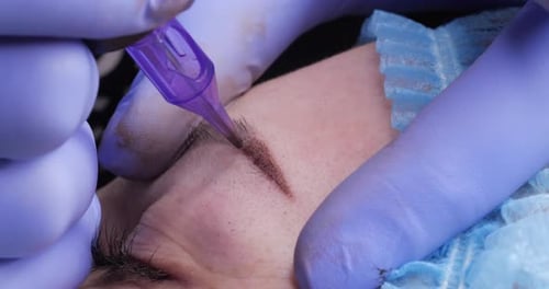 Cosmetic Procedure Applying Permanent Makeup to Eyebrow
