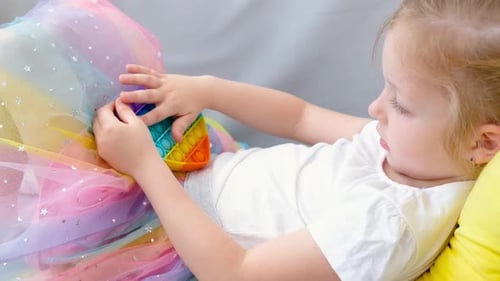 Little Girl Plays with a Bubble Pop Toy