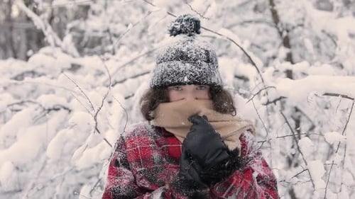 Porträt eines süßen Mädchens, das im Schneewald steht