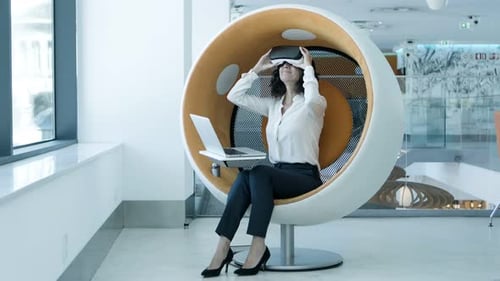 Woman Uses VR Headset and Laptop in Office