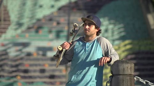 Young Man with Skateboard Standing Outdoors