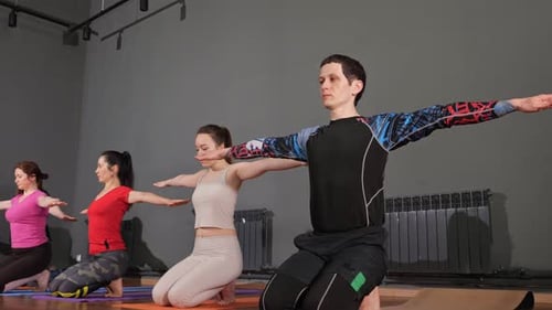 Yoga Class Stretching Arms in a Bright Studio