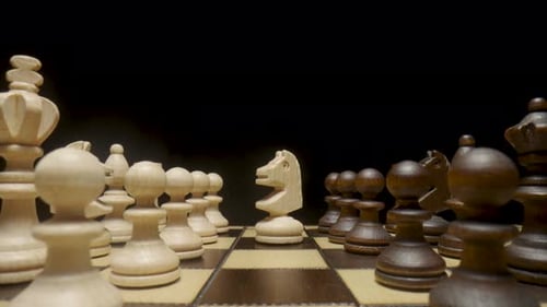 Die Kamera schwenkt über ein Schachbrett mit platzierten Schachfiguren und konzentriert sich auf das weiße Pferd