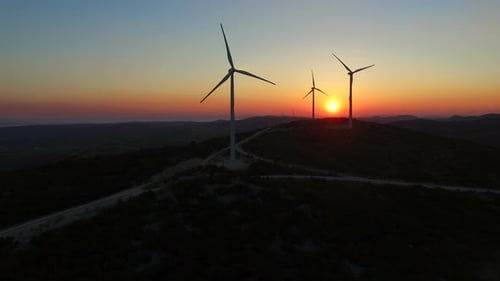 Luftaufnahme von Windmühlen bei wunderschönem farbenfrohen Sonnenuntergang