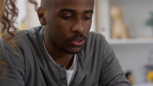 Man Listening to Woman in Indoor Setting