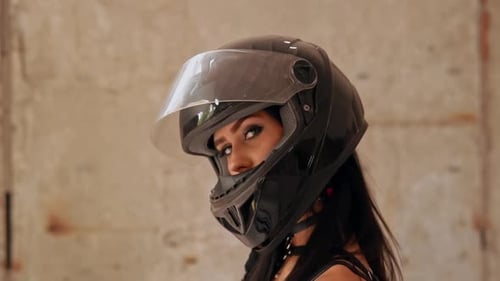 Woman wearing motorcycle helmet in urban setting