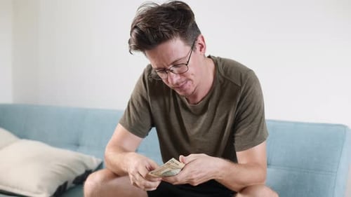 Les mains des hommes comptent les espèces, les dollars et les autres devises à la maison dans une pièce lumineuse