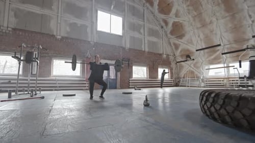 Female Cross Training Athlete Raising Heavy Barbell