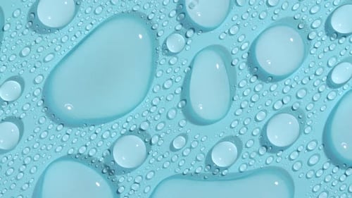 Macro Shot of Cosmetic Moisturizing Drops of Liquid on a Greenblue Pastel Background