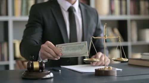 Close Up Shoot of Lawyer Hand Putting Money in Scale