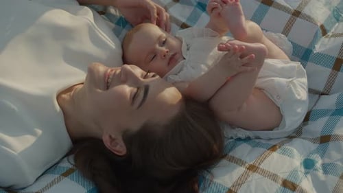 Mother and Baby Relaxing on Picnic Blanket