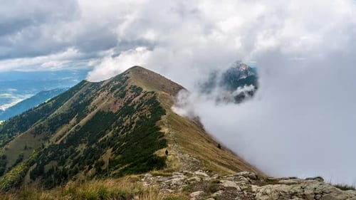 Majestic Mountain Range With Dramatic Clouds and Hiker