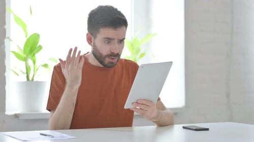 Young Man Having Loss on Tablet in Office
