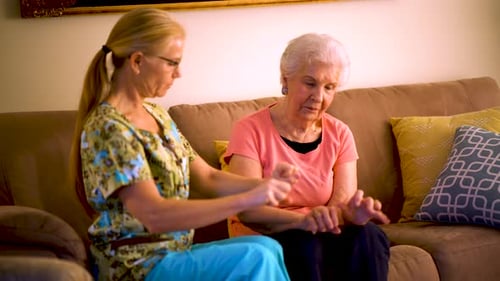 Caregiver Guiding Senior Woman Through Gentle Arm Exercises