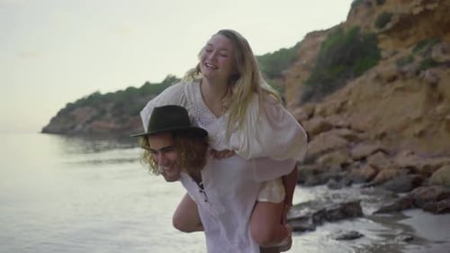 Couple Piggyback Riding on Beach Shores