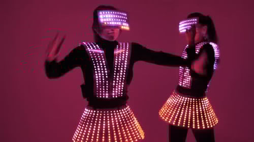 Two Disco Dancers Move in UV Costumes