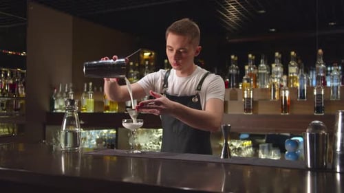 Bartender Pours Alcohol in Glass at the Bar