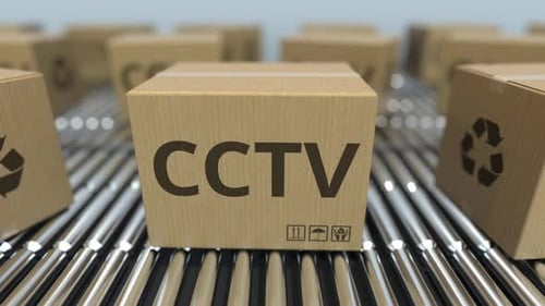 Cajas de cartón con equipo de CCTV en transportadores de rodillos