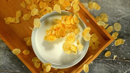 Corn Flakes Pouring into Milk Bowl Overhead Shot
