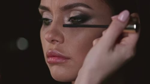 Young Woman Applying Mascara for a Glamorous Look