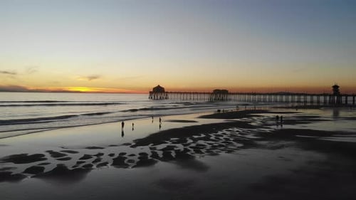 Golden Sunset at Beach with Pier and People