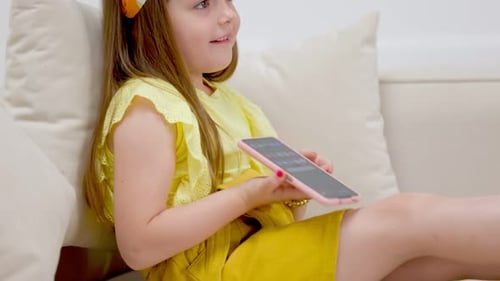 Happy Child Uses Smartphone on Comfortable Couch
