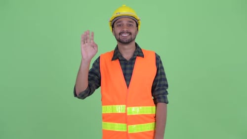 Happy Young Bearded Persian Man Construction Worker Waving Hand