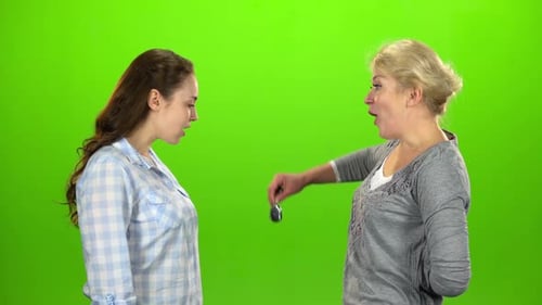 Une femme donne les clés à sa fille. Écran vert. Vue latérale