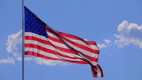 American Flag Waving Proudly Against Blue Sky