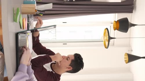 Young Adult Typing at Laptop Indoors